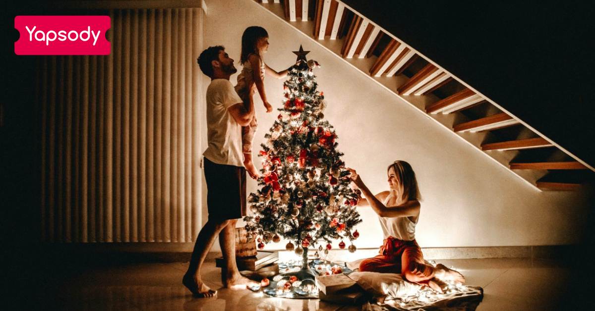 Yapsody Event Ticketing Blog - Christmas Ideas For Event Organizers - A cute family decorating the Christmas tree